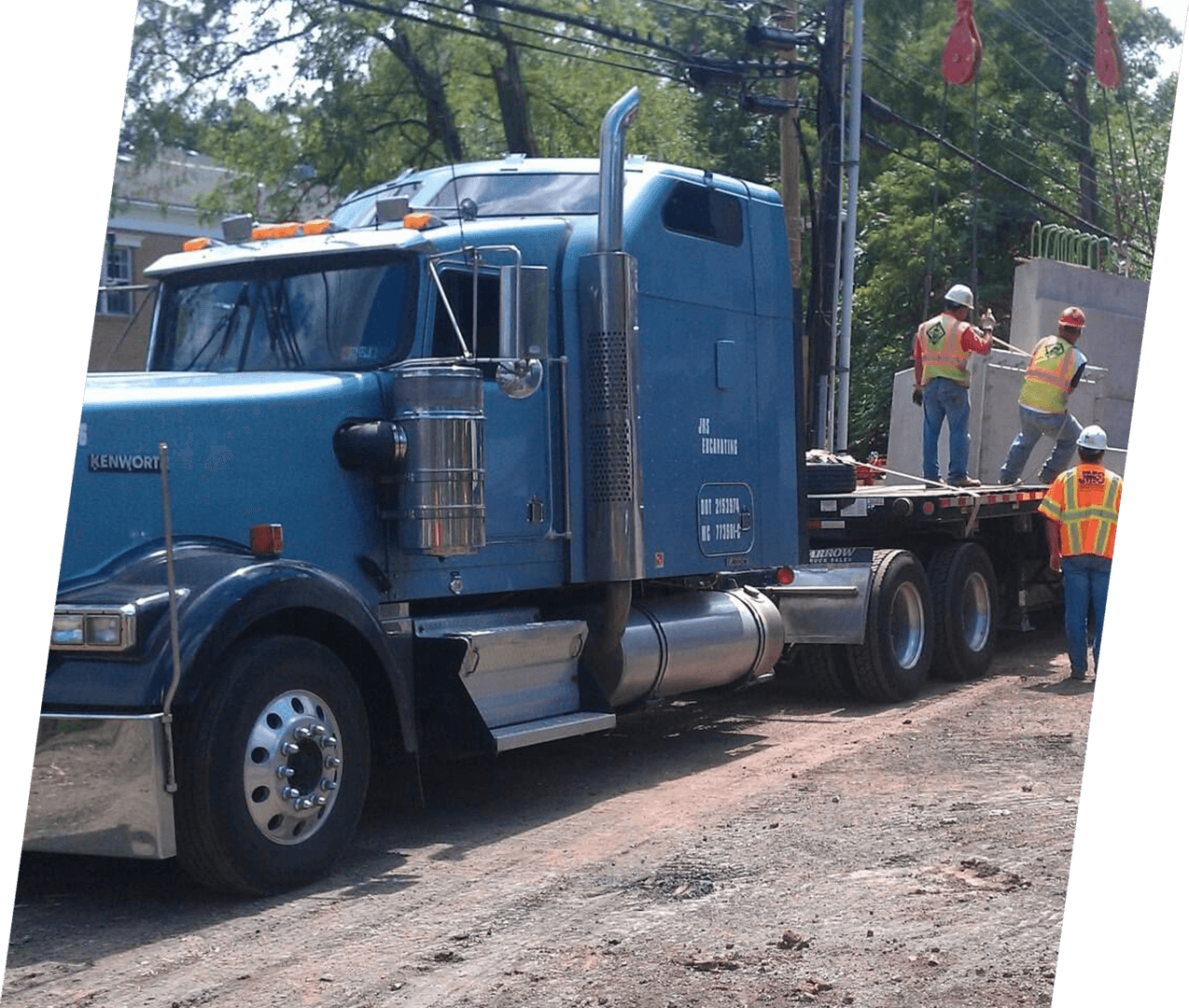 A large blue truck with people standing around it.