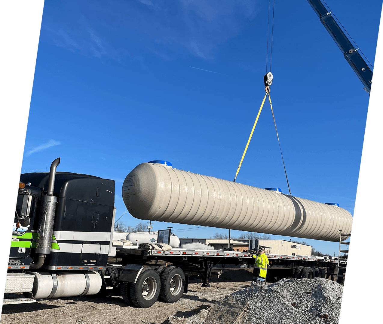 A large white tank being lifted by crane.