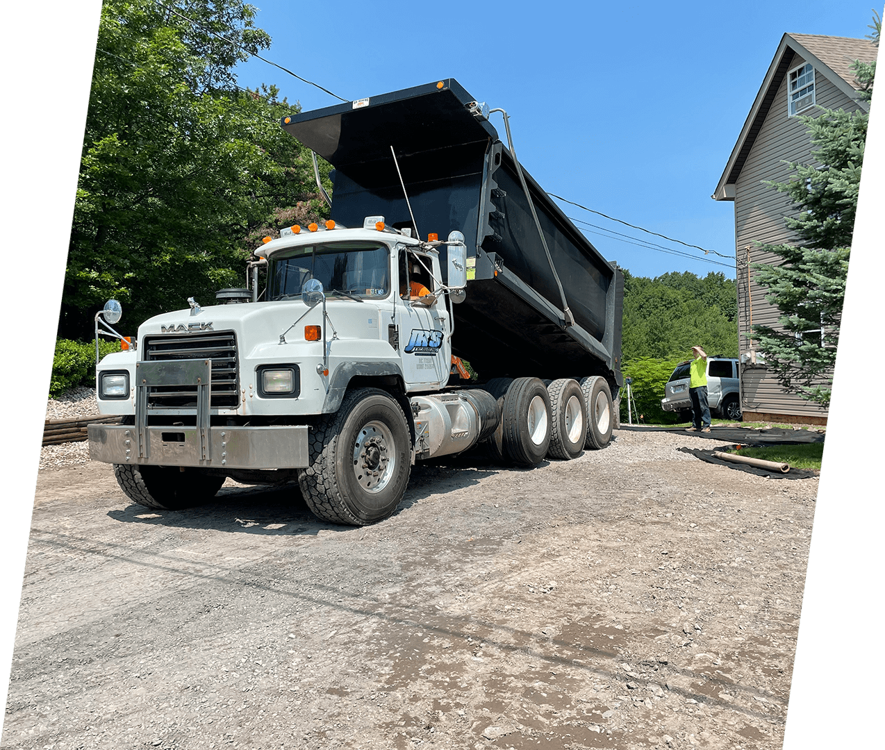 A dump truck is parked on the side of a road.