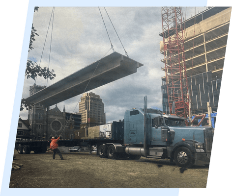 A large truck is being lifted by crane.