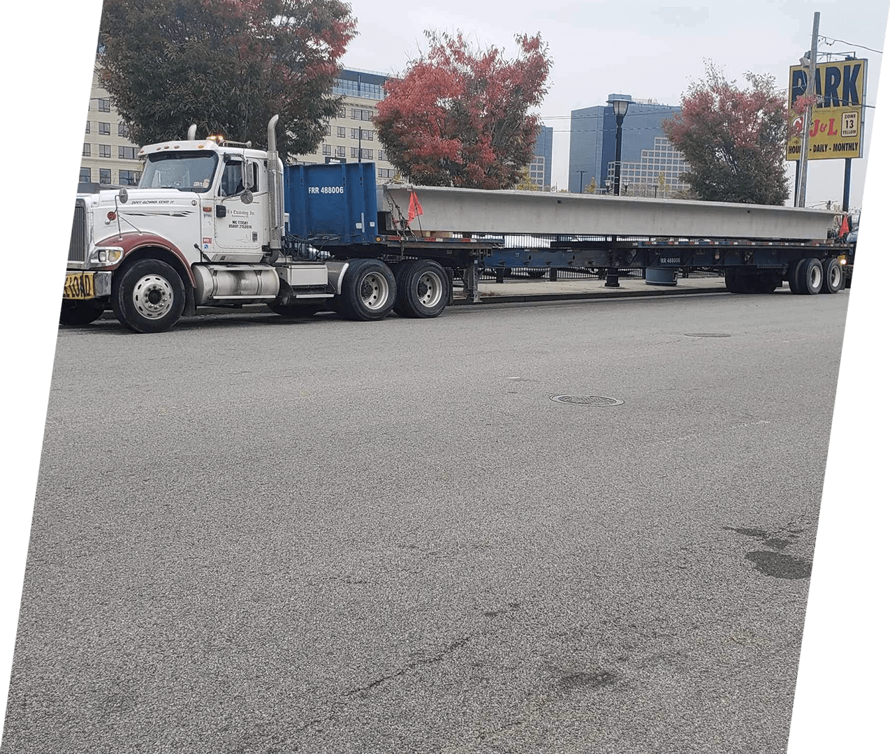 A semi truck is driving down the street.