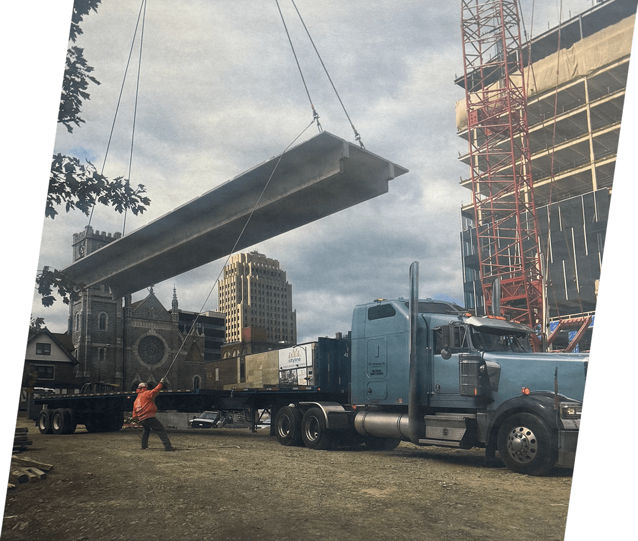 A large truck is being lifted by crane.