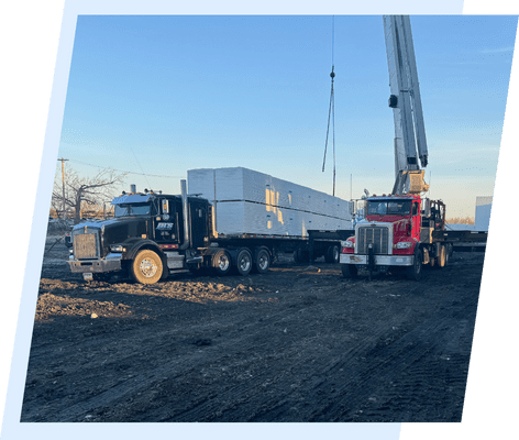 A large truck is being loaded with a crane.