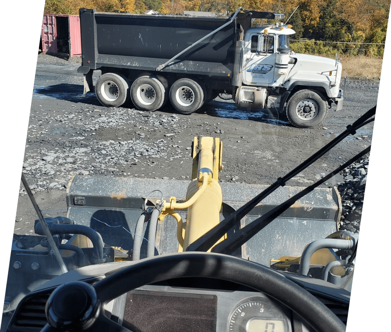 A dump truck is parked in the middle of a road.