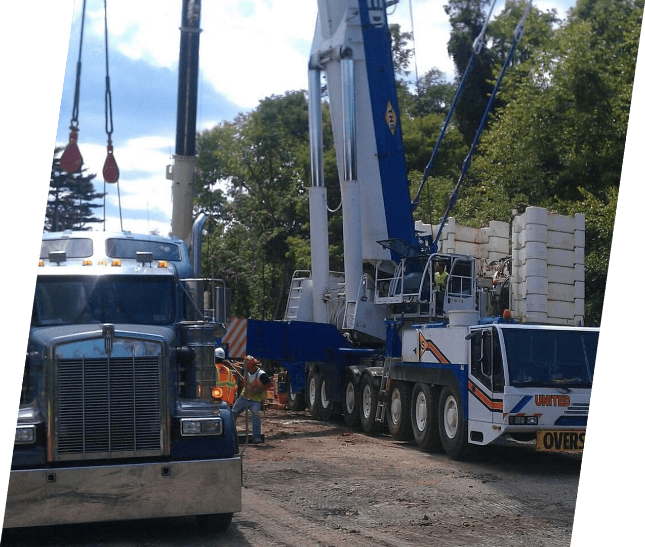 A large truck is parked next to a crane.