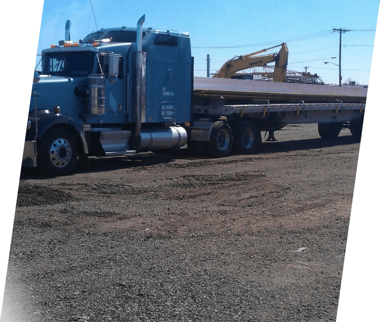 A large blue truck is pulling a trailer.