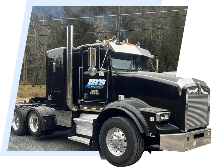 A black semi truck is parked on the side of the road.